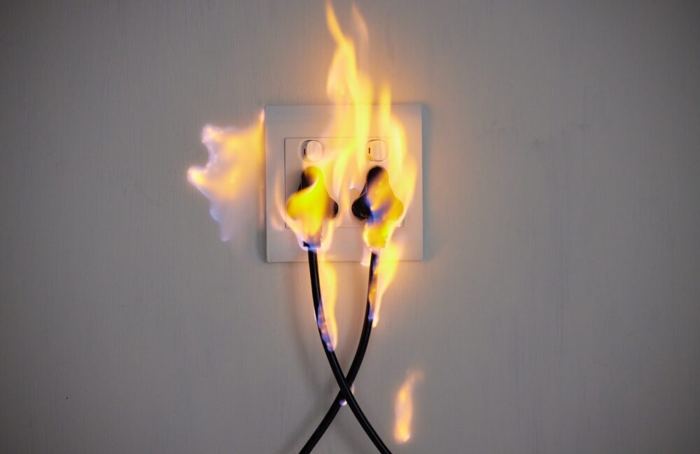 Flaming electrical outlet with items plugged in